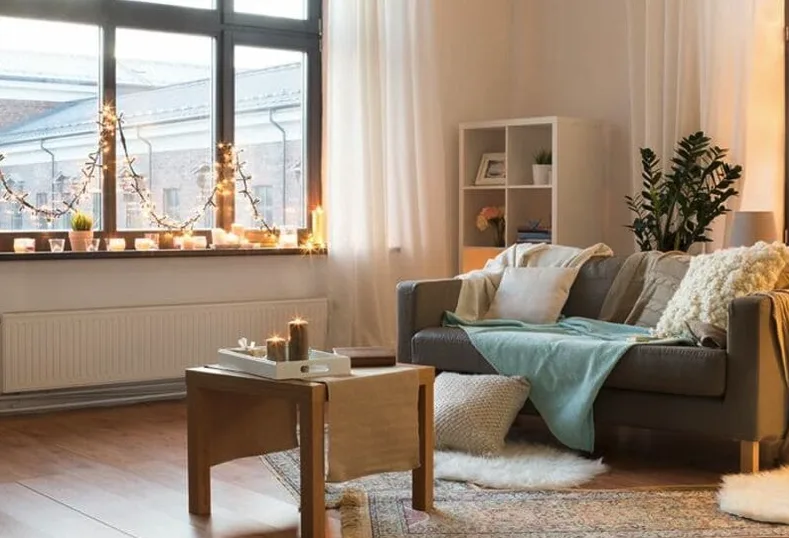 Salón acogedor con luces cálidas, manta y cojines